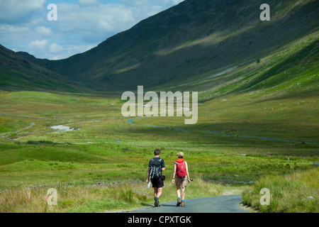 Couple Walking Through Hard Knott Pass dans le Parc National du Lake District, Cumbria, Royaume-Uni Banque D'Images