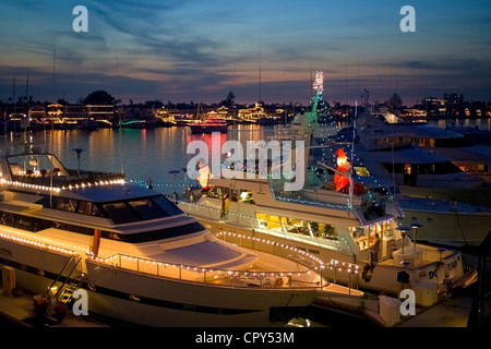 La lumière des yachts jusqu'à rejoindre d'autres navires illuminés dans Newport Harbor pour le défilé de Noël annuel de voile à Newport Beach en Californie du Sud, aux États-Unis. Banque D'Images