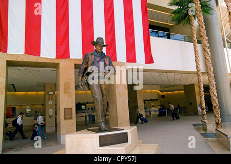 Une statue rend hommage à la star de cinéma célèbre à John Wayne John Wayne Airport à Santa Ana, Orange County, Californie, USA. Banque D'Images