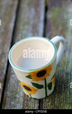 Tasse de café avec le tournesol décoration sur une table de jardin en bois Banque D'Images