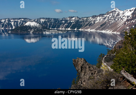 Une vue panoramique de Crater Lake, Oregon, USA montrant l'île de l'assistant et de nuages réflexions sur le lac. Prise en juin. Banque D'Images