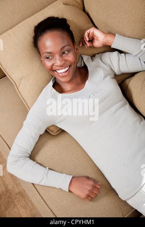 Woman relaxing on couch, Famille, Illovo Johannesburg, Afrique du Sud. Banque D'Images