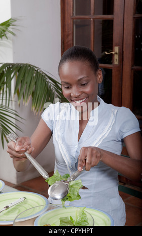 Une femme mettre en salade, Famille, Illovo Johannesburg, Afrique du Sud. Banque D'Images