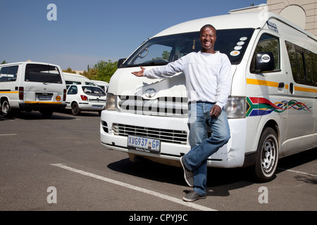 Chauffeur de taxi se trouve en face de son taxi, smiling at camera Banque D'Images