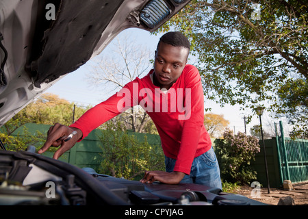 Homme africain travaillant sur un moteur de voiture Banque D'Images