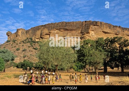 Mali Pays Dogon Ennde corvée d'eau après l'école jusqu'au village est bien bas de Bandiagara est classé au Patrimoine Mondial de Banque D'Images