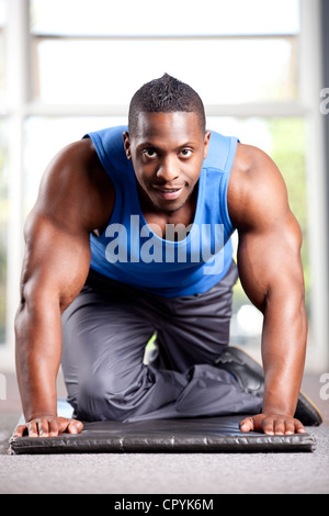 Jeune homme noir musclé pose dans une salle de sport Banque D'Images