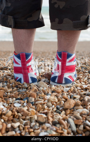 Paire de union jack flag formateurs sur la plage Banque D'Images