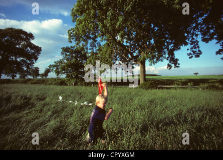 Boy running avec kite dans domaine yorkshire uk Banque D'Images