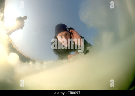 Plongeur à la recherche dans un trou de glace, plongée sous glace, plongée sous-glaciaires, dans la mer Noire, congelé un phénomène rare Banque D'Images