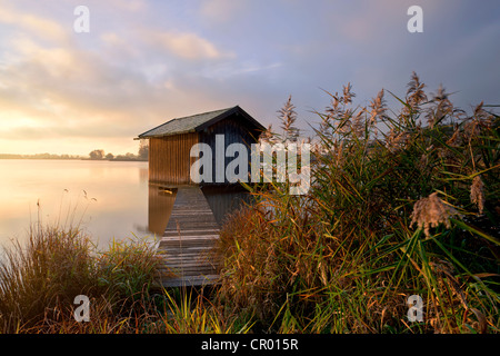 Lever du soleil avec une cabane de pêcheur et une légère brume du matin près de Rimsting, sur le lac de Chiemsee, en Bavière, Allemagne, Europe, PublicGround Banque D'Images