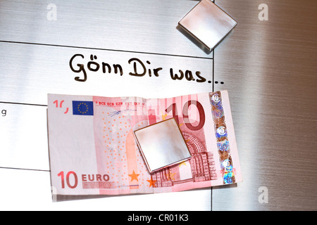 10-billet d'euro relié à un tableau d'affichage magnétique, avec le message 'Goenn a dir', l'allemand pour "Offrez-vous quelque chose Banque D'Images