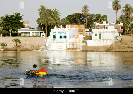 L'Egypte, la Nubie, Egypte, vallée du Nil, l'île Eléphantine, enfant dans un petit bateau et maisons nubiennes Banque D'Images