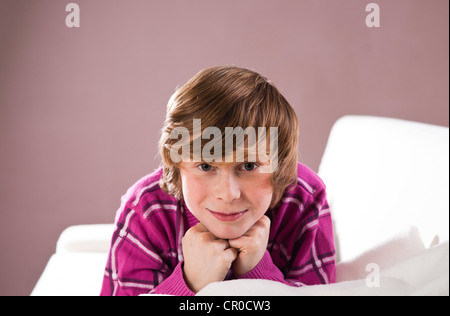 Smiling boy lying on a couch Banque D'Images