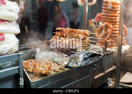 Un vendeur alimentaire chariot sert des grillades de shish kebab dans la nuit dans la ville de New York. Banque D'Images