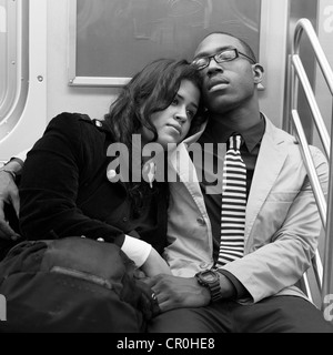 Un jeune couple se détend ensemble sur le métro de New York. Banque D'Images