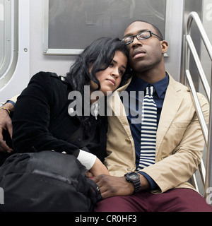 Un jeune couple se détend ensemble sur le métro de New York. Banque D'Images