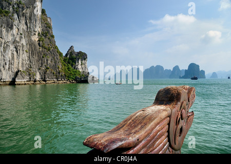 La sculpture sur bois, tête de dragon à la proue sur une jonque Halong Bay, à l'arrière du cône de karst, au Vietnam, en Asie du sud-est Banque D'Images