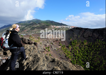 Femme sur le bord du cratère du volcan San Antonio près de Fuencaliente, surplombant Los Canarios, La Palma, Canary Islands, Spain Banque D'Images