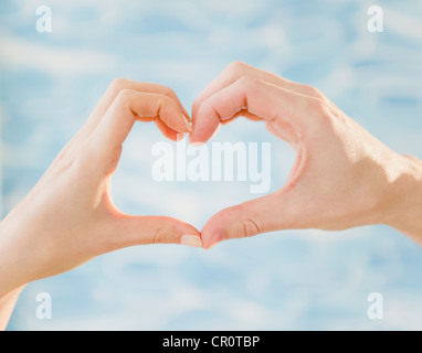 Close up of man's woman's hands et décisions forme de cœur, studio shot Banque D'Images