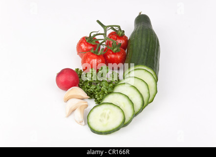 Le concombre et tranches de concombre, tomates cerises, radis, gousses d'ail et persil Banque D'Images