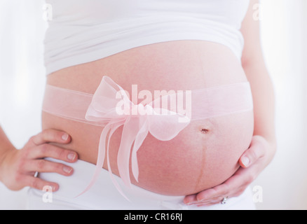 USA, New Jersey, Jersey City, femme enceinte avec ruban rose sur son ventre Banque D'Images