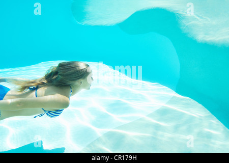 Woman in bikini swimming in pool Banque D'Images