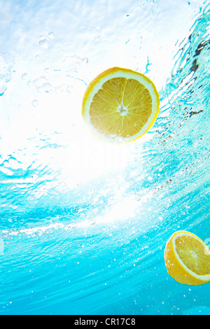 Citrons floating in swimming pool Banque D'Images