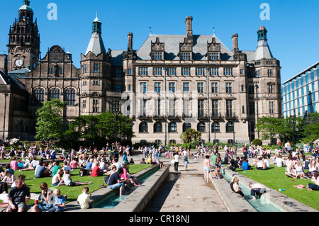 Les gens se détendre dans la chaleur de la paix jardins en face de l'hôtel de ville de Sheffield. Banque D'Images