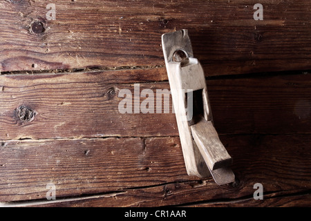 Vieux bois avion hanging on a rustic wooden wall Banque D'Images