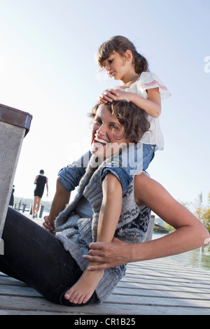 Mother and Daughter sitting on pier Banque D'Images