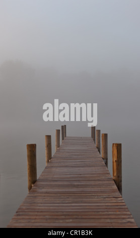 Wharf dans le brouillard sur le lac Staffelsee avec l'île de Woerth près de Seehausen, Murnau, Upper Bavaria, Bavaria, PublicGround Banque D'Images