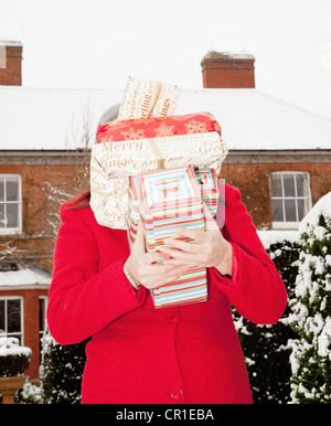 Woman wrapped gifts in snow Banque D'Images