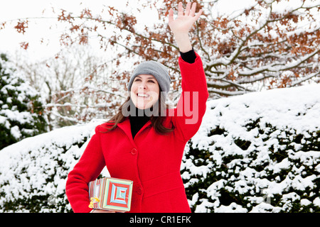 Woman wrapped gift in snow Banque D'Images