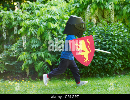 Garçon jouant avec sword in backyard Banque D'Images