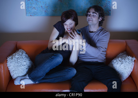 USA, Californie, Los Angeles, jeune couple fighting over TV remote control Banque D'Images