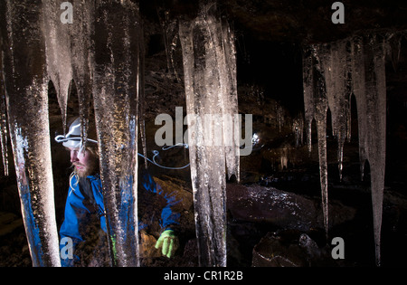 Randonneur avec les glaçons en grotte glaciaire Banque D'Images