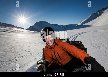 Woman driving motoneige en champ neigeux Banque D'Images