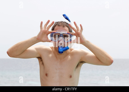 Man adjusting goggles, prêt à faire de la plongée, les Maldives, l'Océan Indien Banque D'Images