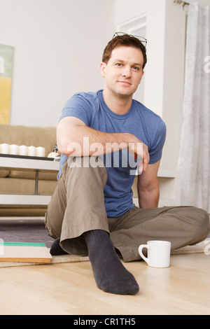 USA, Californie, Los Angeles, Portrait of a Mid adult man sitting on floor Banque D'Images