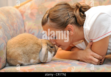 Fille avec un nain européen Lapin (Oryctolagus cuniculus) Banque D'Images