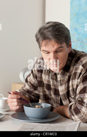 USA, Californie, Los Angeles, l'homme de manger le petit déjeuner et reading newspaper Banque D'Images
