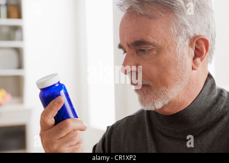 USA, Californie, Los Angeles, Senior men reading label on medicine bottle Banque D'Images