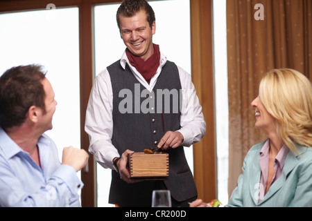 Waiter serving business people in cafe Banque D'Images