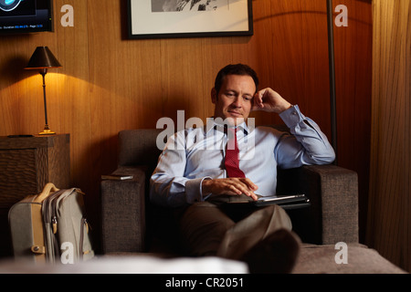 Businessman using tablet in hotel room Banque D'Images