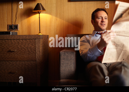 Businessman reading in hotel room Banque D'Images