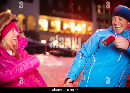 Couple pulling Christmas Cracker in snow Banque D'Images