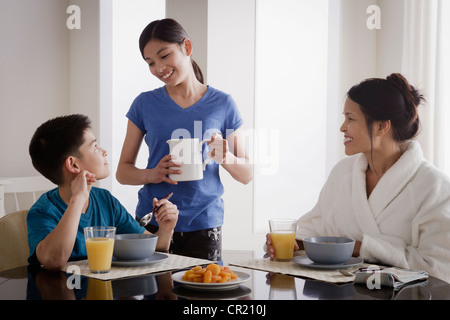 USA, Californie, Los Angeles, Girl servant à la famille du lait au petit déjeuner Banque D'Images