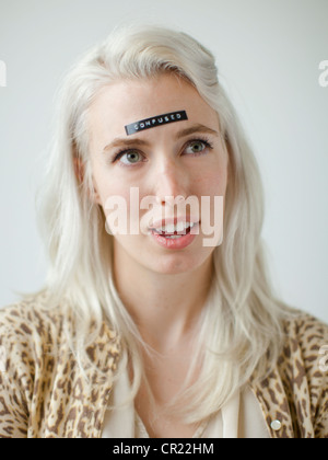 Portrait de jeune femme confuse avec étiquette noire sur le front Banque D'Images