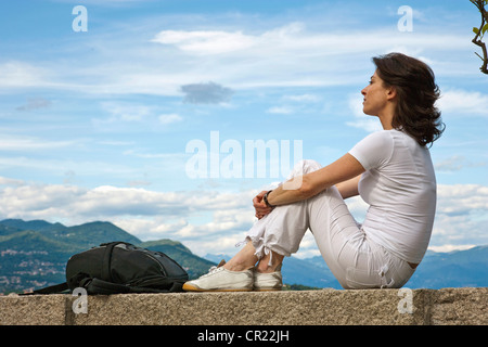 Woman relaxing on stone wall Banque D'Images